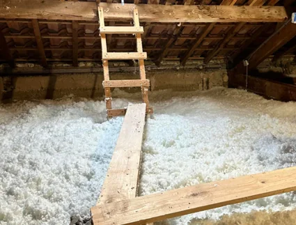 Laine minérale soufflée dans des combles, échelle d’accès au premier plan